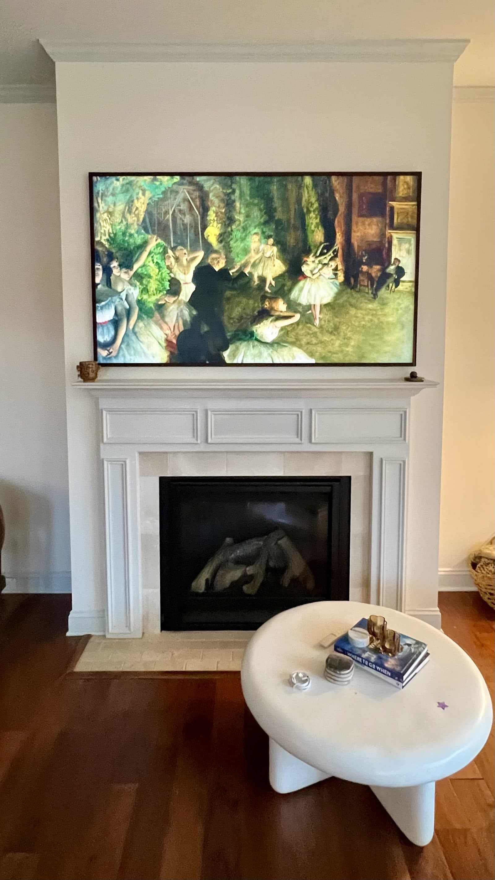 Frame TV displaying a Degas ballet painting above a white mantel