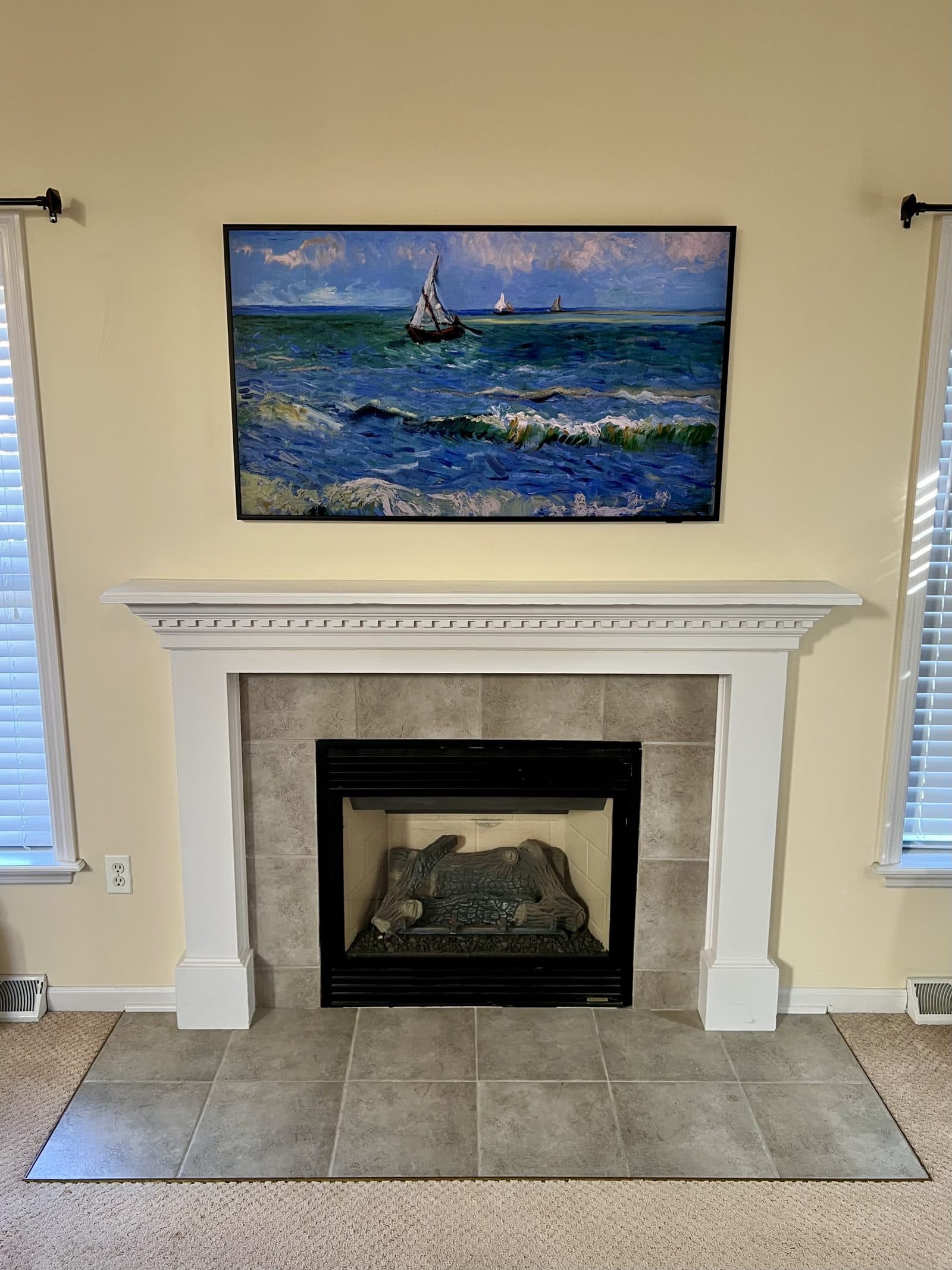 Frame TV displaying a van Gogh seascape above a tiled fireplace