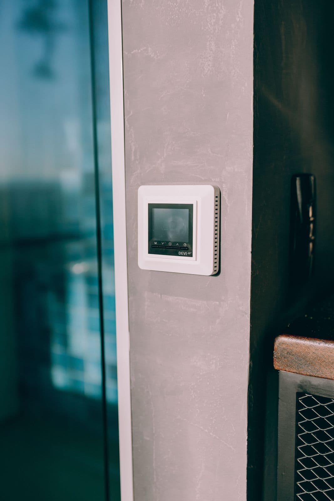 White smart touch control panel mounted on a concrete wall